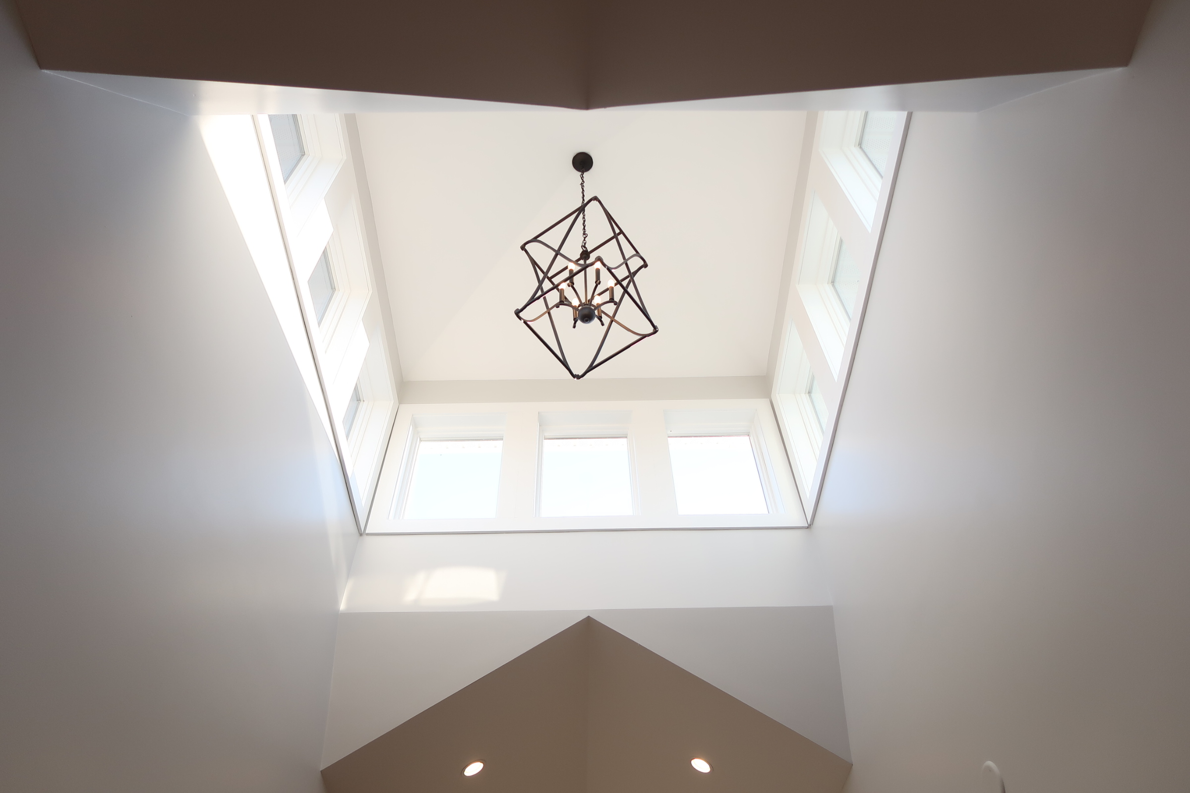 interior of a home with a chandelier and windows. 