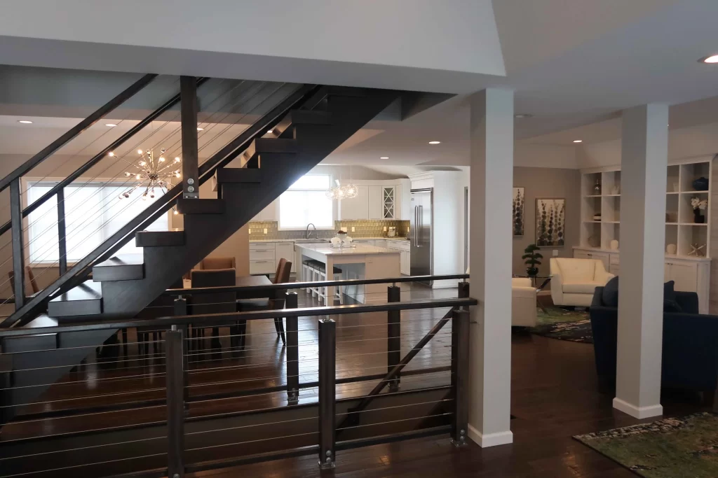 Spacious open-concept home design by NEPA Builders showcasing a modern staircase, elegant kitchen with a large island, and cozy seating area in Blakely